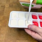 pouring almond milk into ice cube tray
