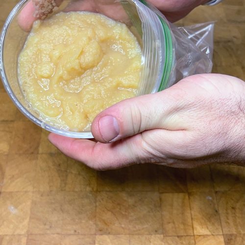 pouring a bowl of applesauce into a freezer bag
