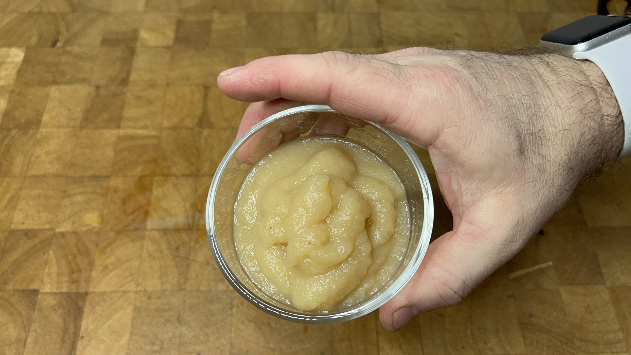 bowl of defrosted applesauce sitting on a wooden table