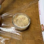 placing plastic wrap over banana pudding
