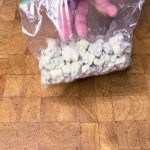 bag of blue cheese crumbles sitting on wooden table