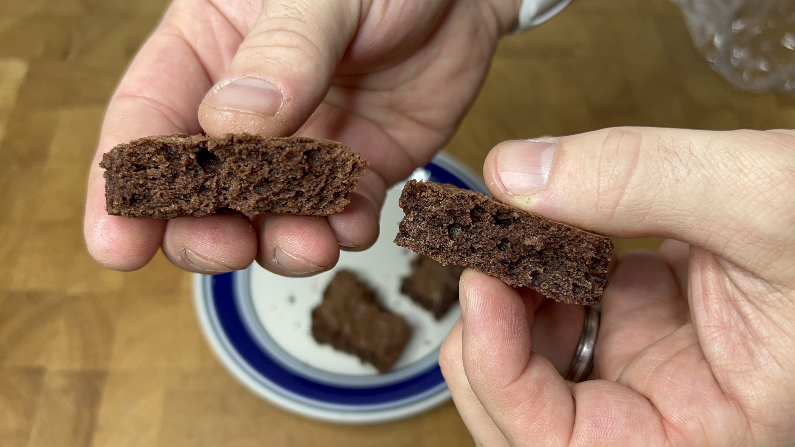 hands holding a fresh brownie on the left and a frozen and defrosted brownie on the right