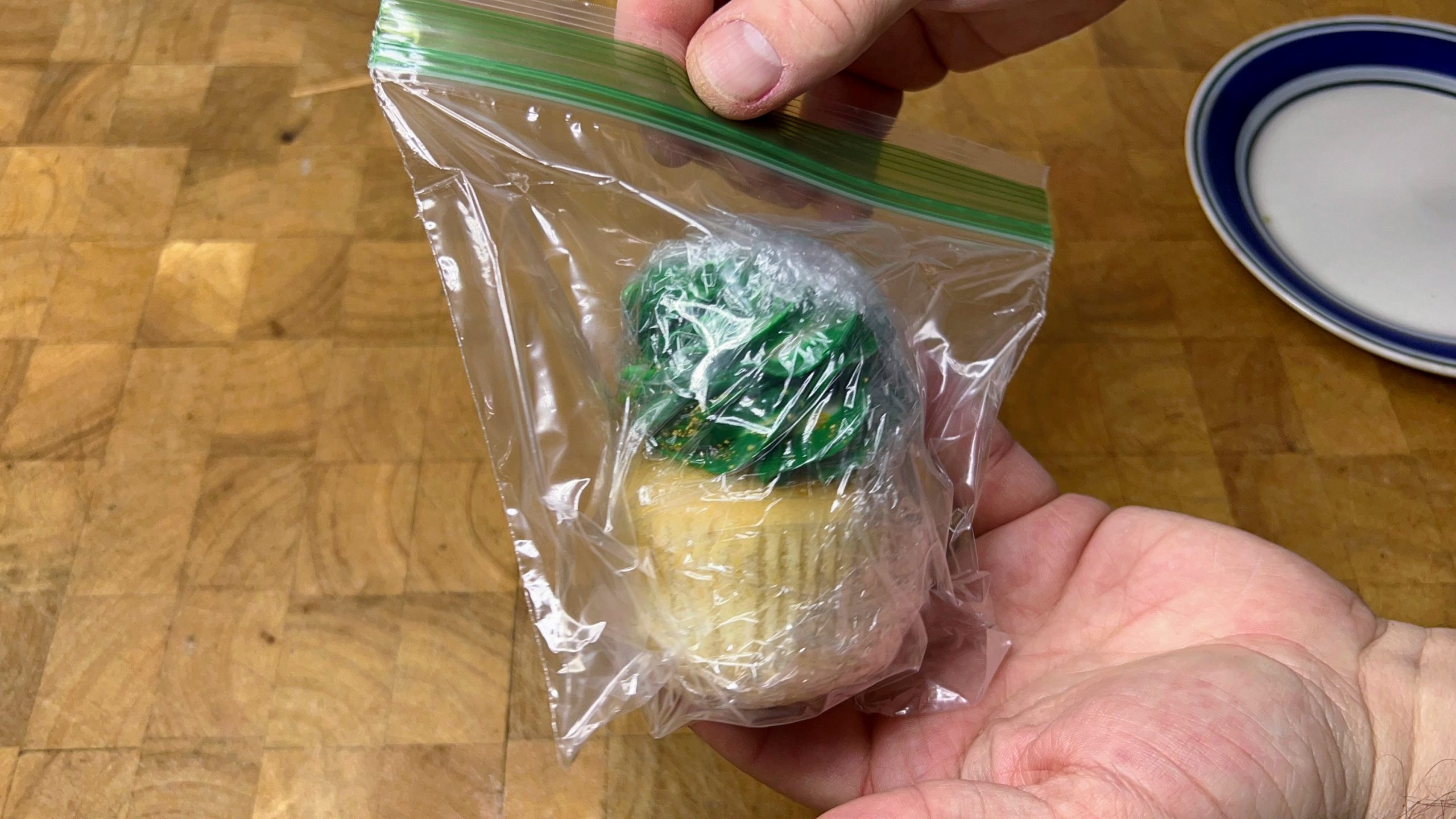 zipping a freezer bag shut with wrapped cupcake inside