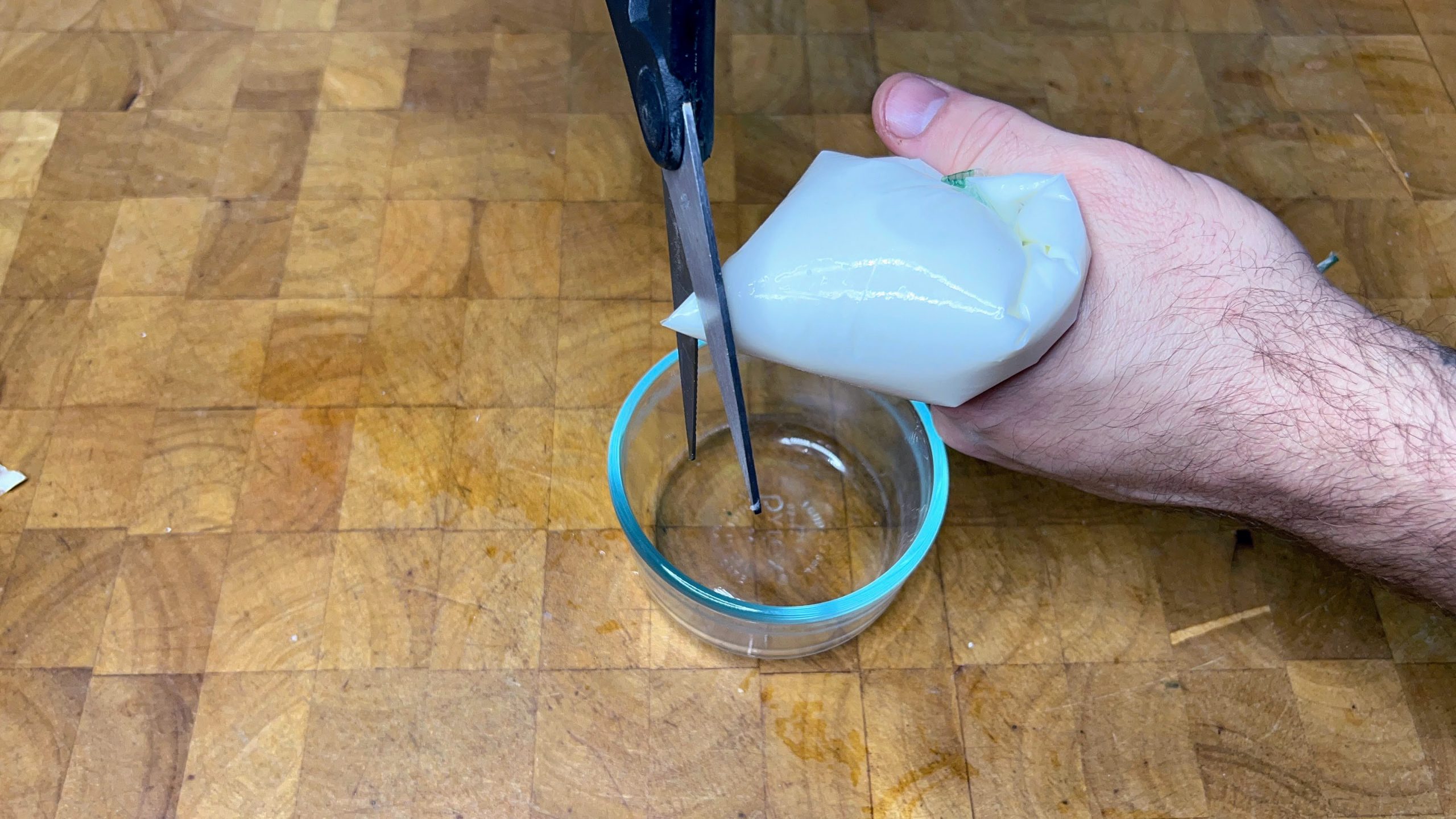 clipping the end off a bag of defrosted greek yogurt