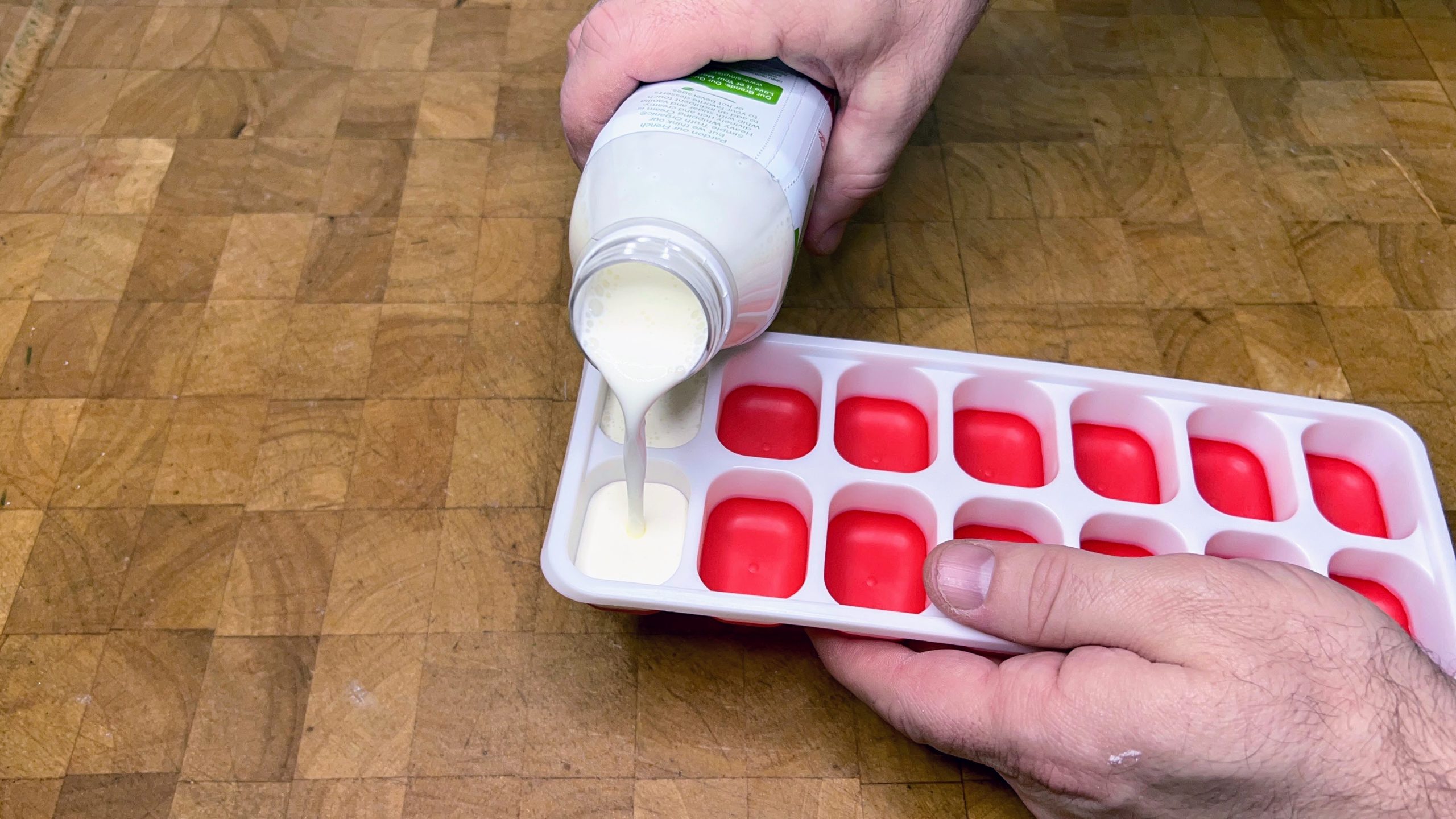 pouring heavy cream into an ice cube tray