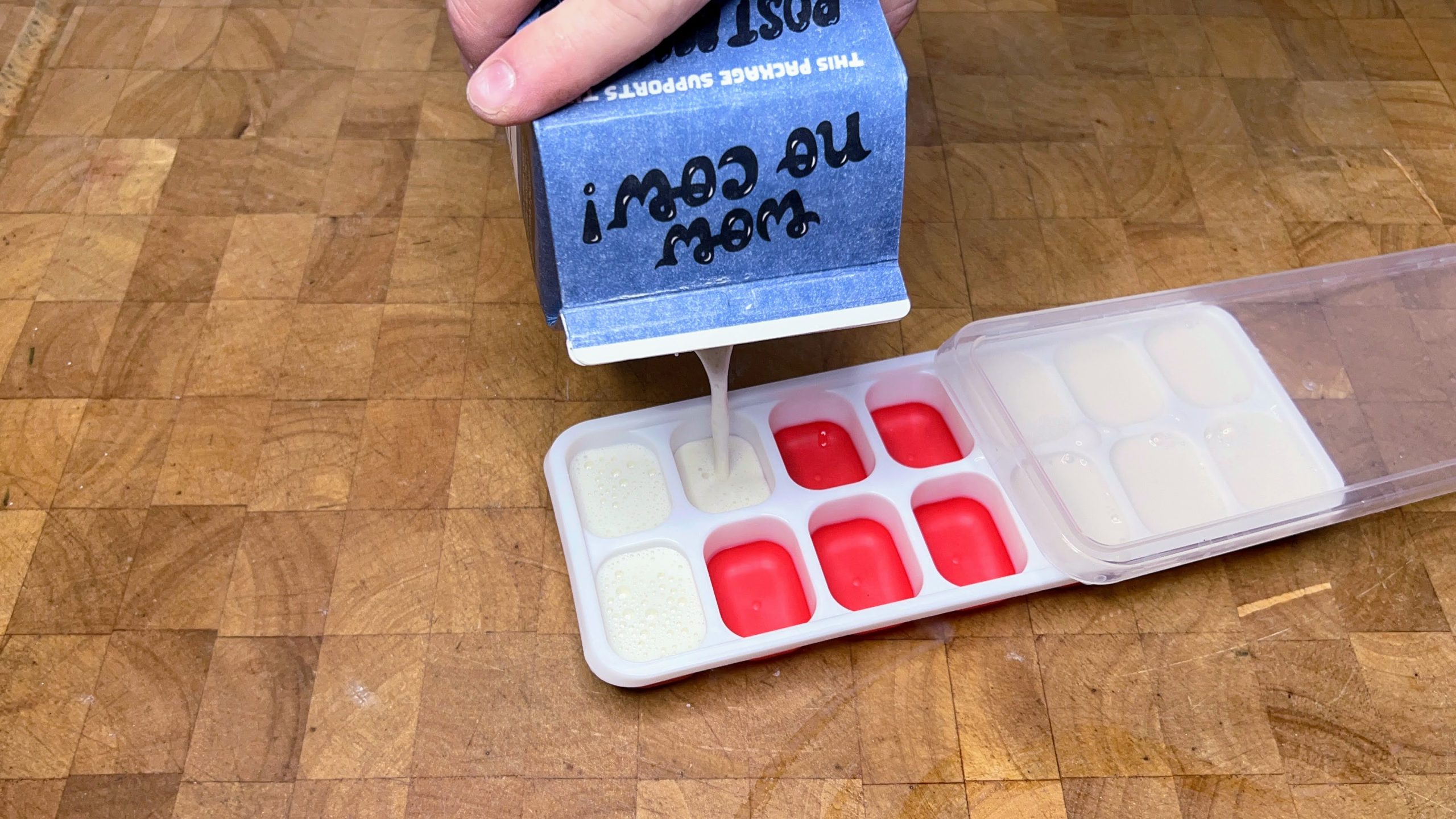 pouring oat milk into an ice cube tray