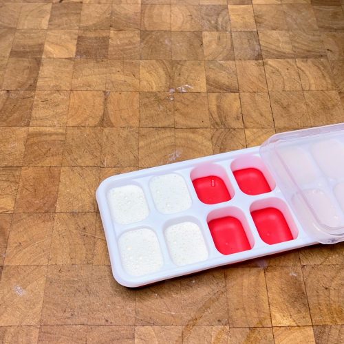 ice cube tray filled with oatmilk with lid on top of it
