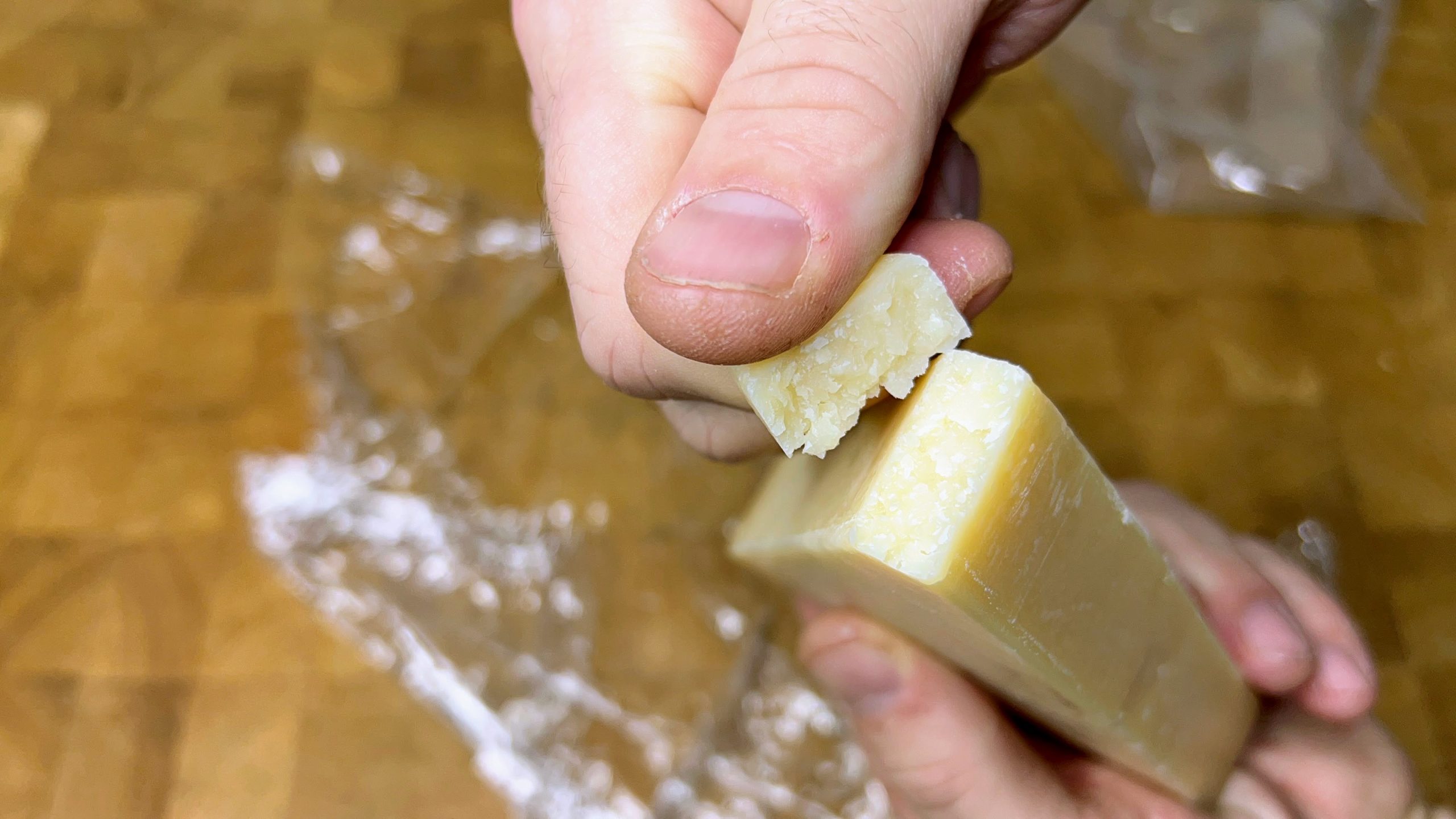 tearing a piece off a block of defrosted parmesan cheese