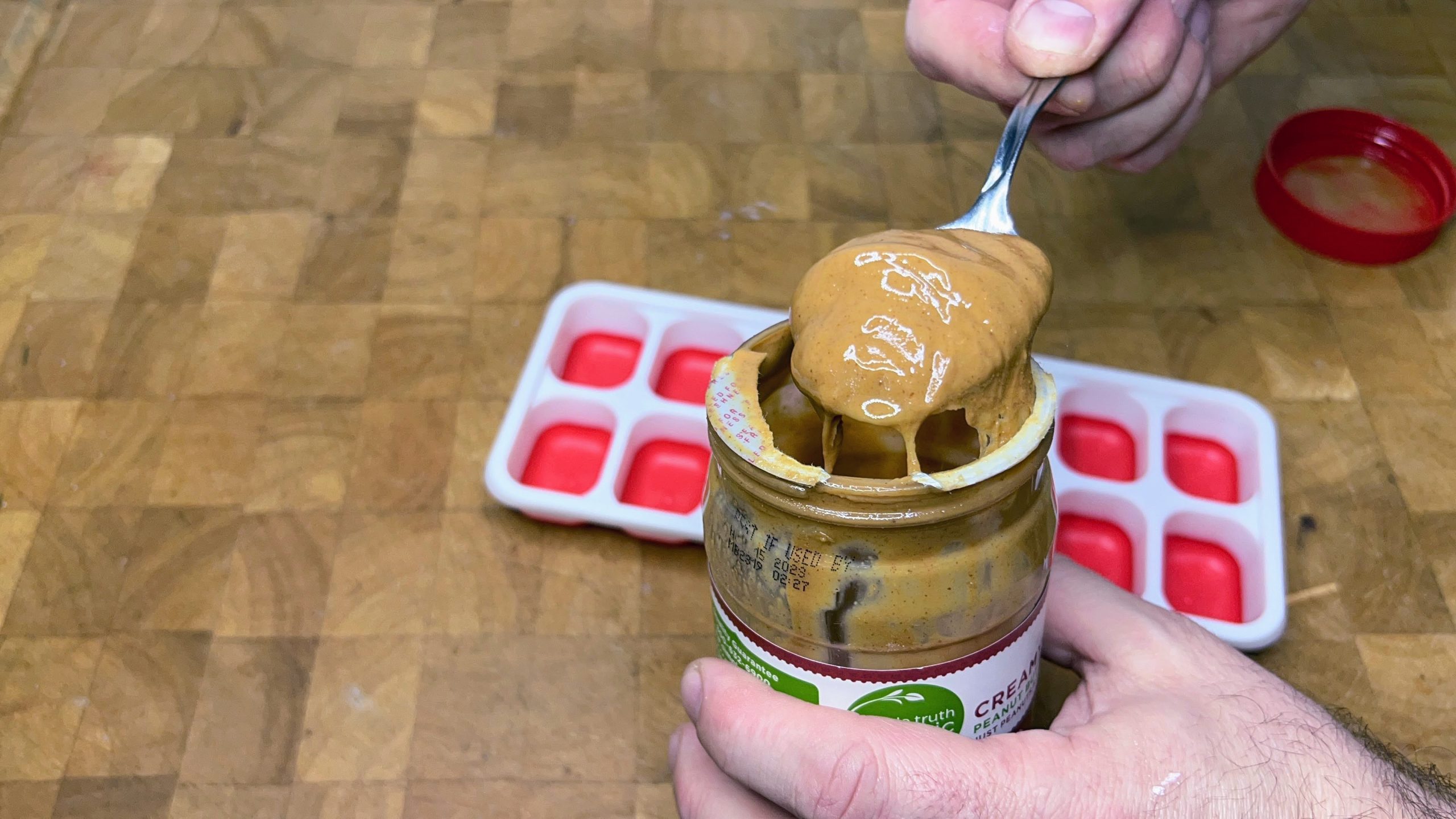 spoonful of peanut butter in front of an ice cube tray