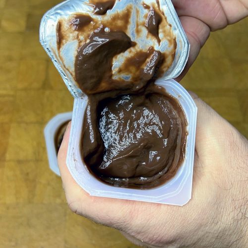 holding a package of chocolate pudding and opening it
