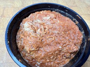 bowl of pulled pork on a wooden table