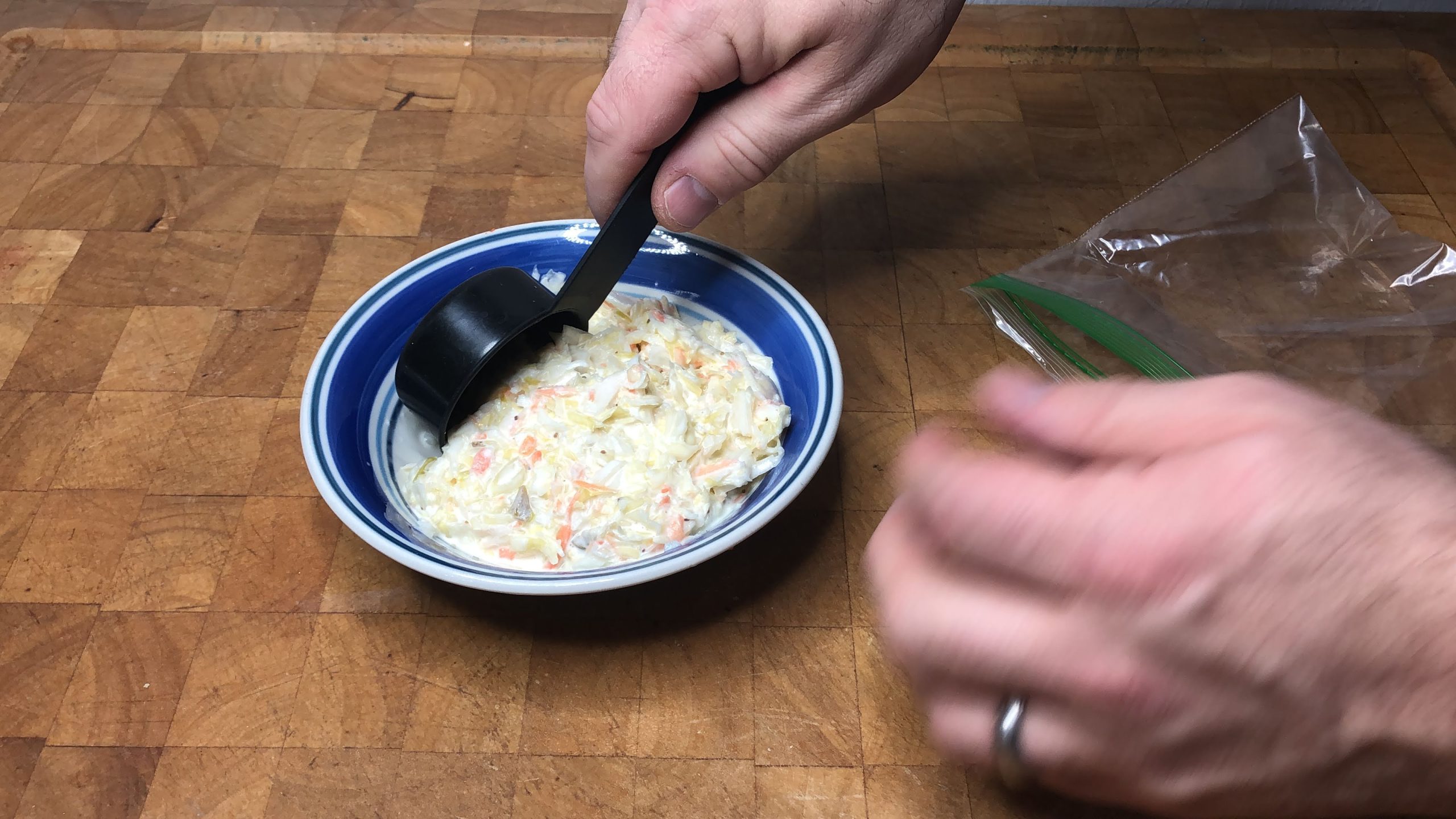 scooping coleslaw into a freezer bag