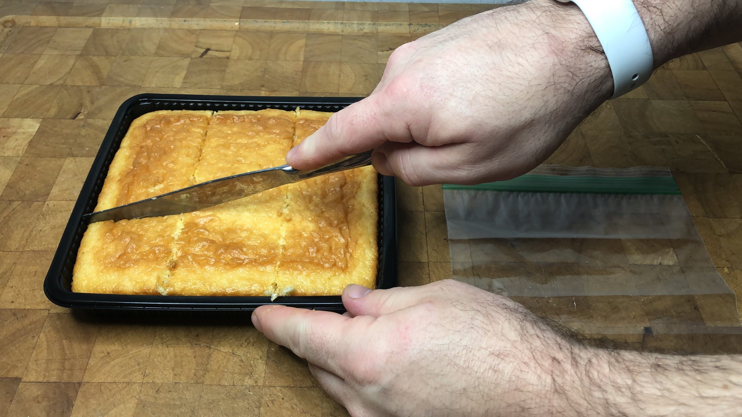 slicing a pan of cornbread
