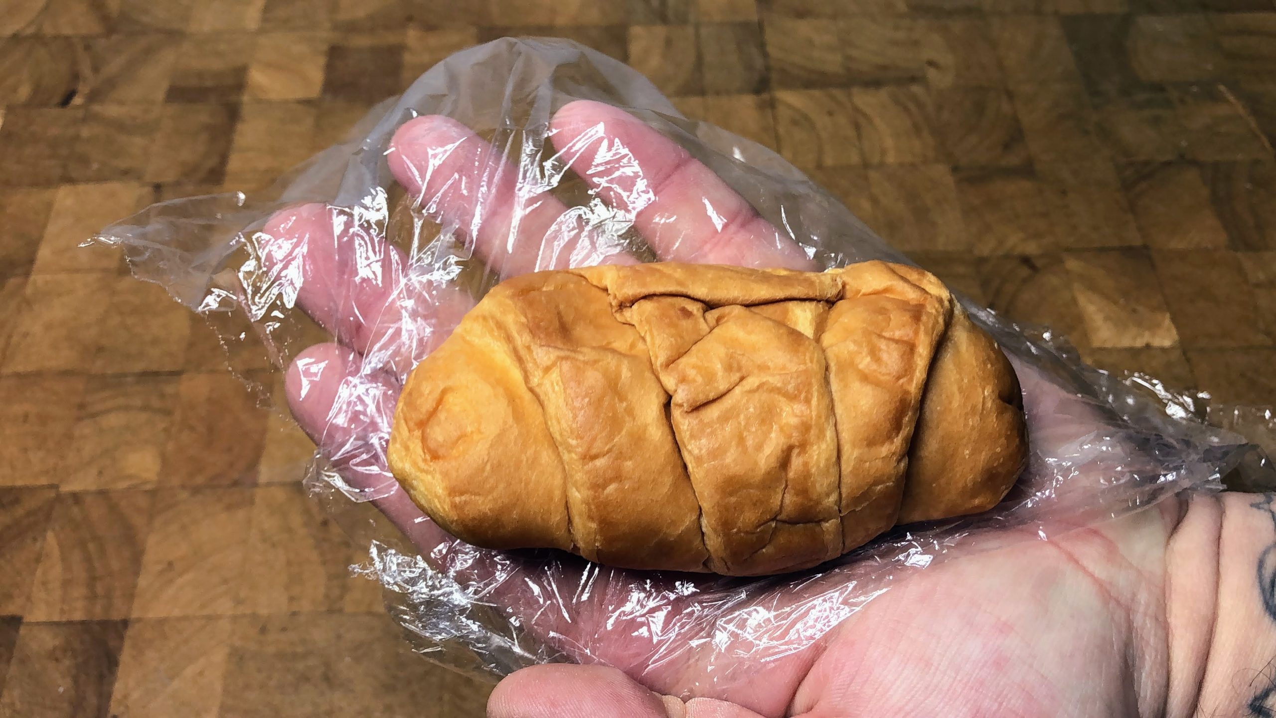defrosted croissant sitting on a sheet of plastic wrap