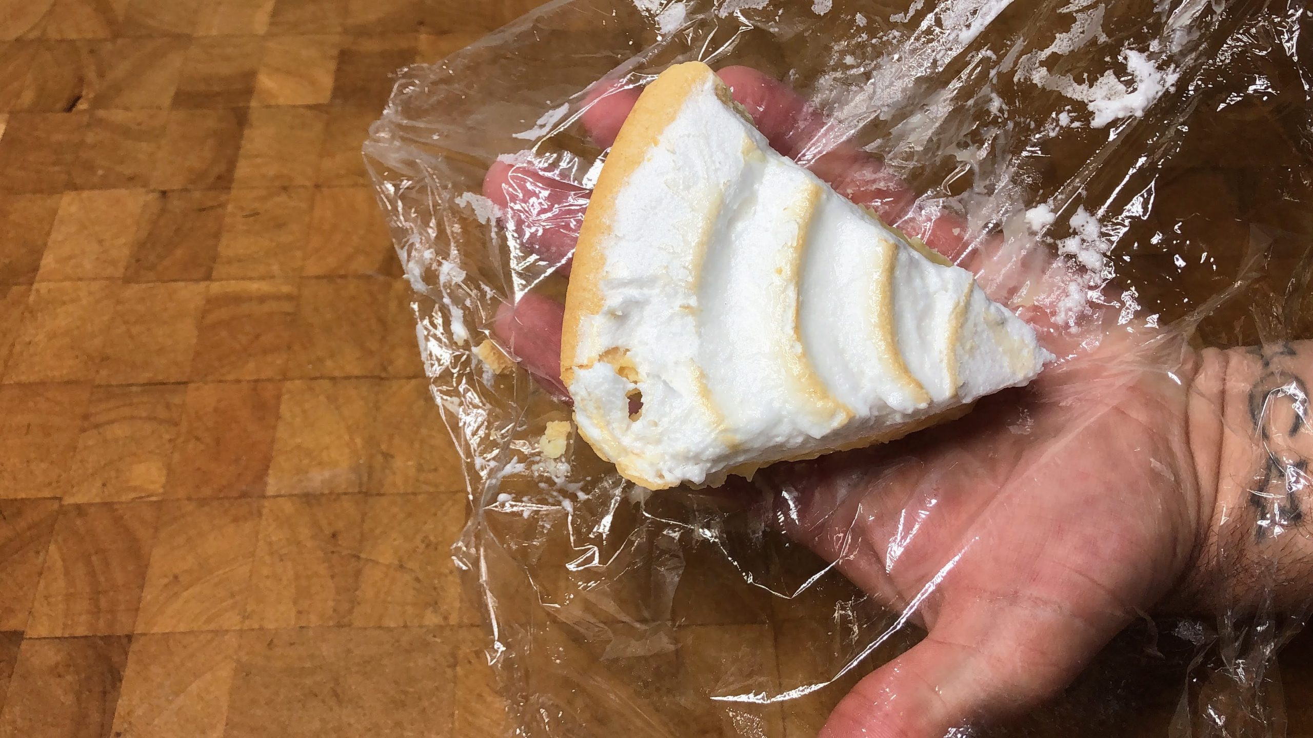 defrosted lemon meringue pie on a sheet of plastic wrap