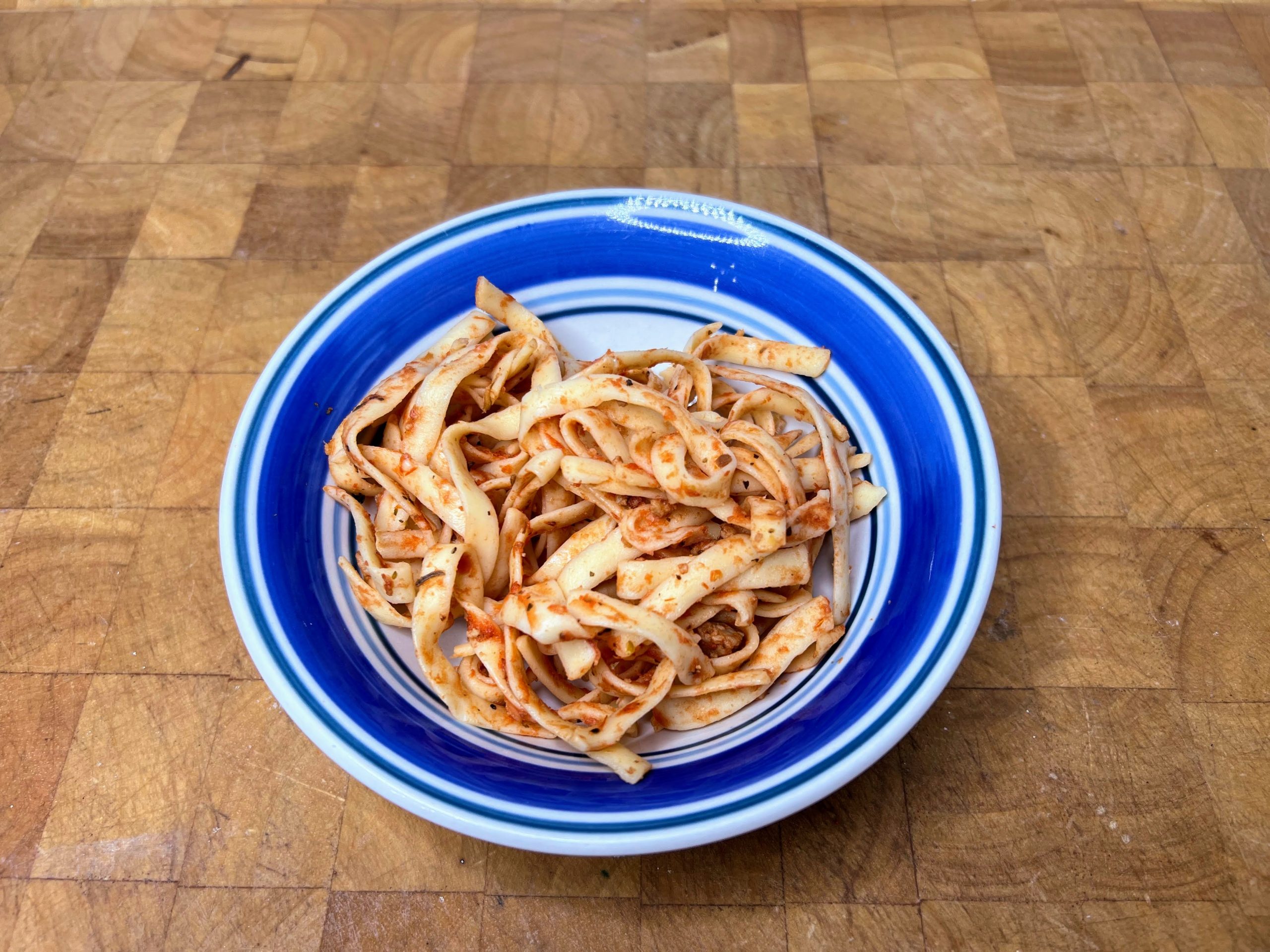 bowl of spaghetti on a wooden table