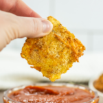 Dipping air fryer ravioli into sauce.
