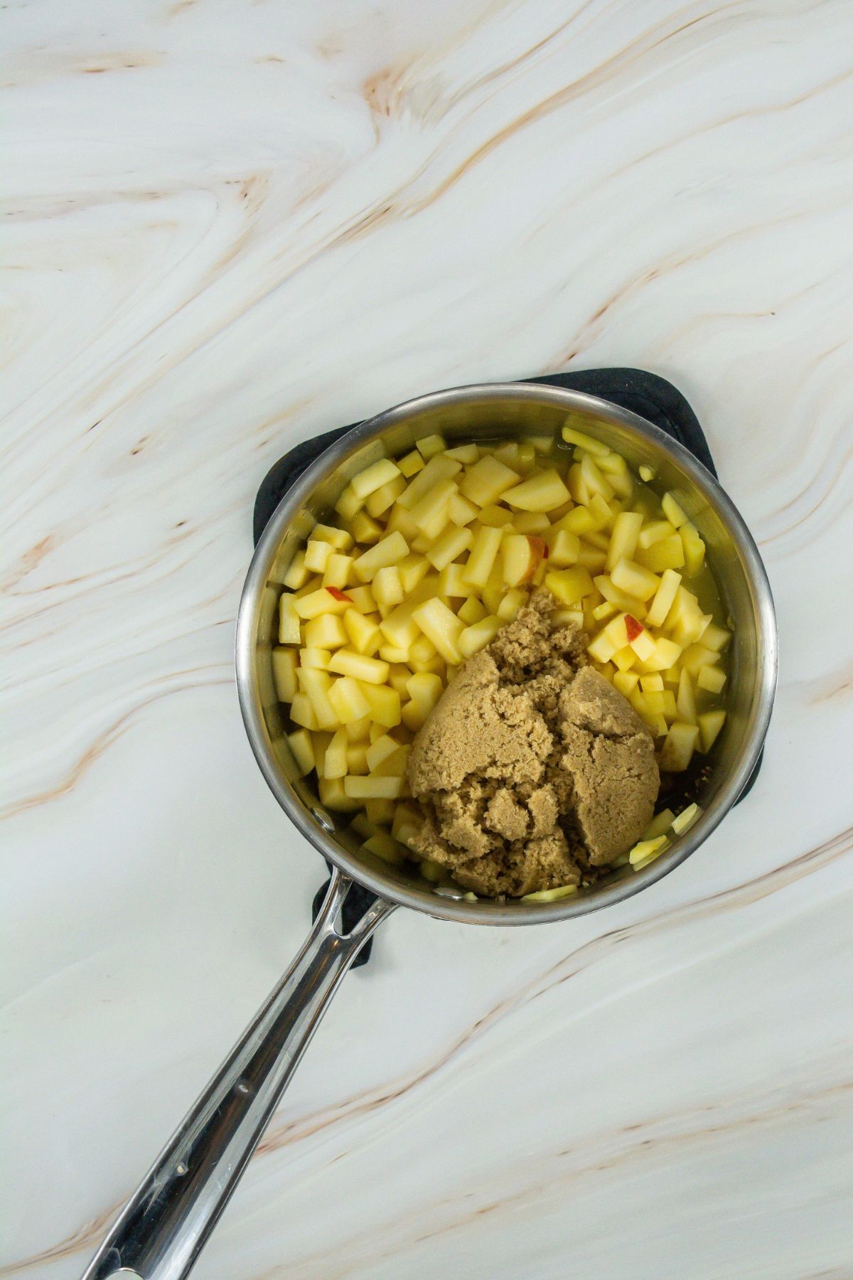 Brown sugar in a pot with apples.