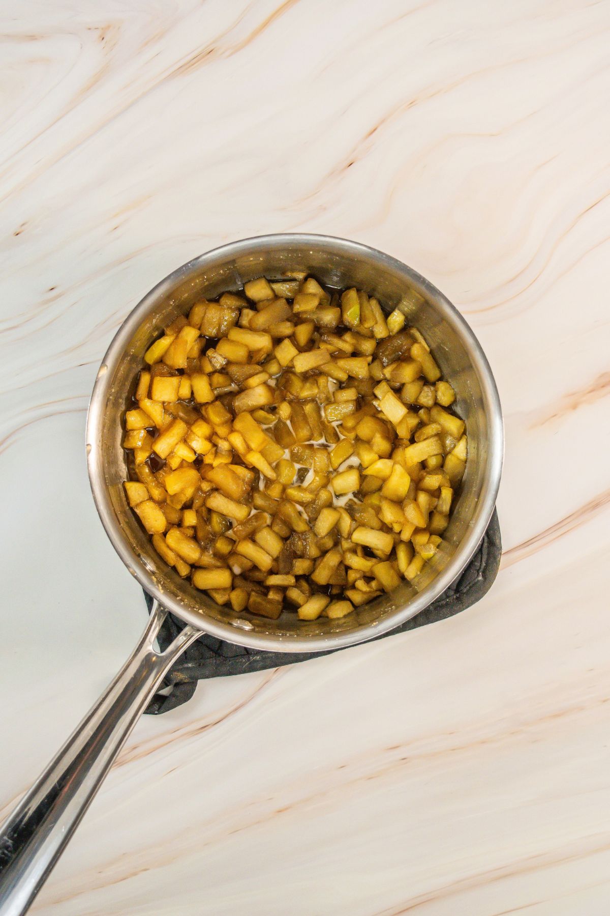 Cooked apples and cinnamon in a pot.