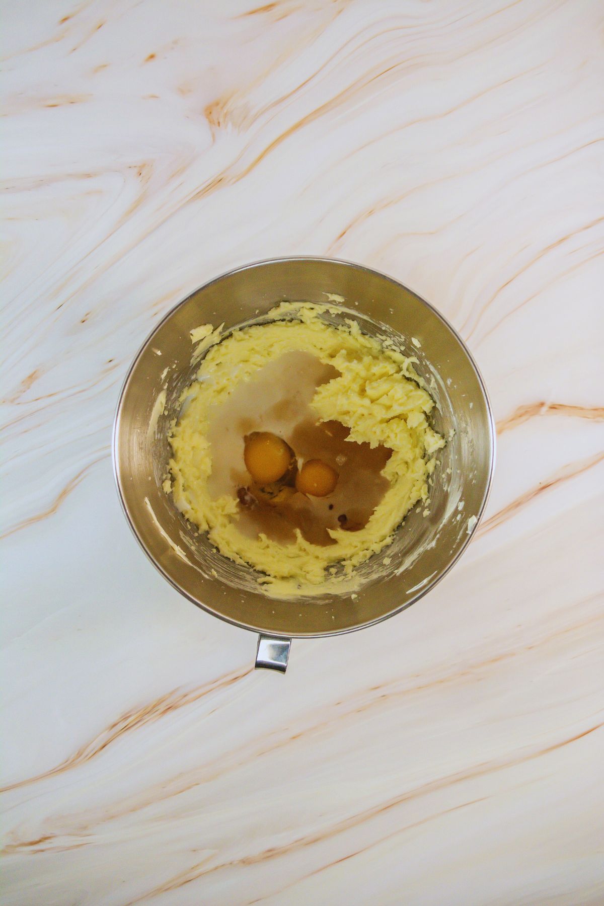 Eggs in creamed butter in a bowl.