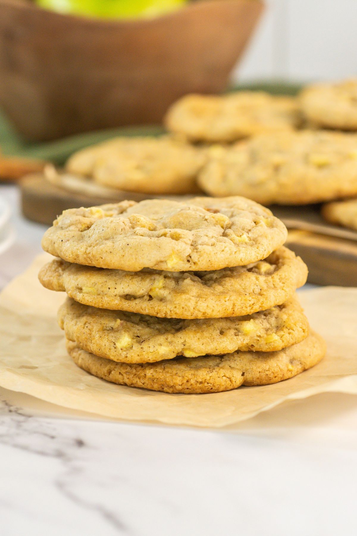 Stack of caramel apple cookies on brown paper.
