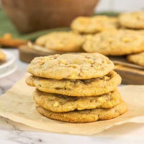 Stack of caramel apple cookies on brown paper.