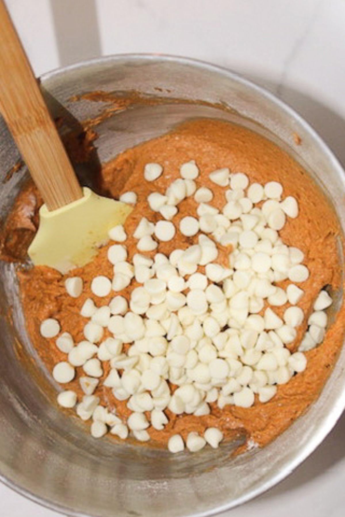 Adding cream cheese morsels into dough.