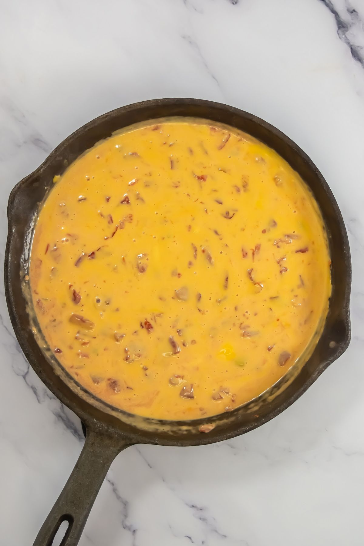 Melted Velveeta with tomatoes in skillet.